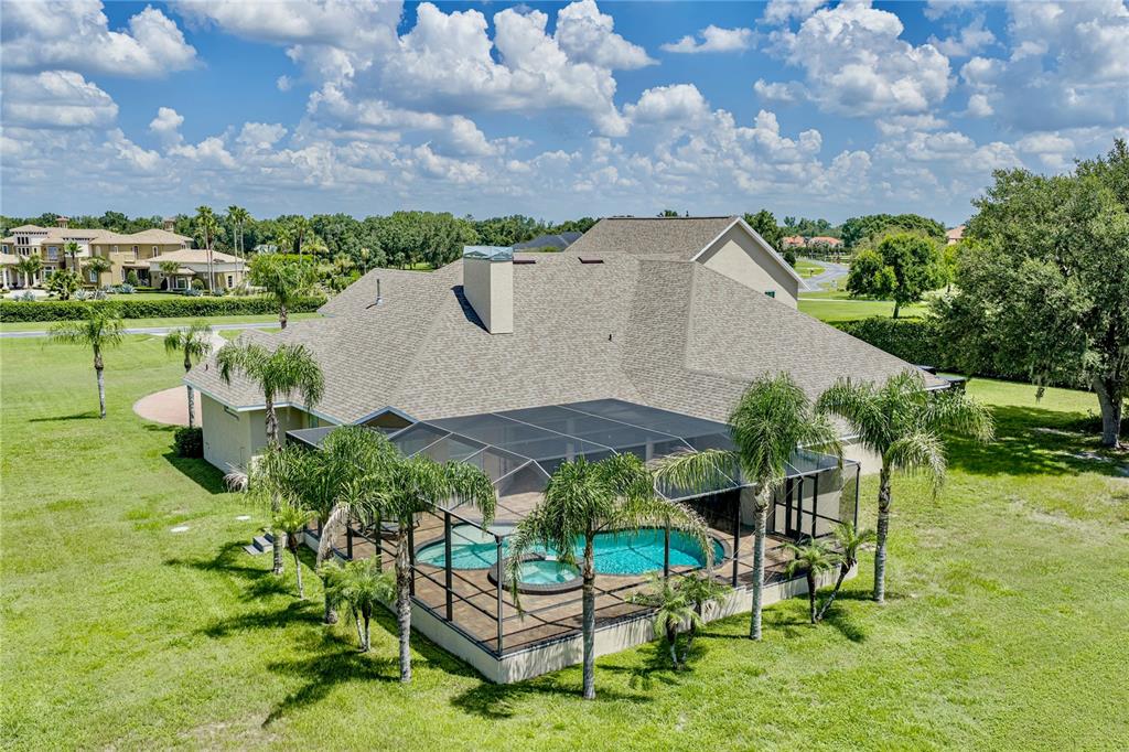 An aerial view of a house with a screened-in pool and spa in a yard — 11518 HAMMOCK OAKS COURT, LITHIA, FL