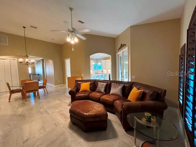 A living room features a large brown leather sectional, an ottoman, and tile flooring — 5461 46TH COURT W, BRADENTON, FL