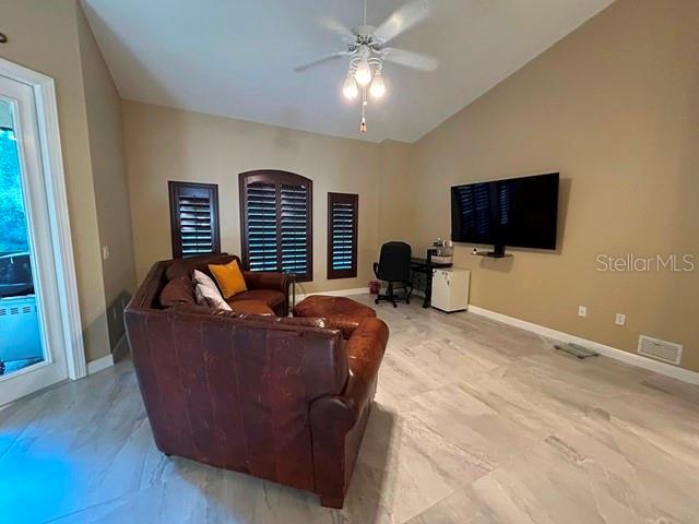 A living room features a leather sofa, a wall-mounted television, and tile flooring — 5461 46TH COURT W, BRADENTON, FL