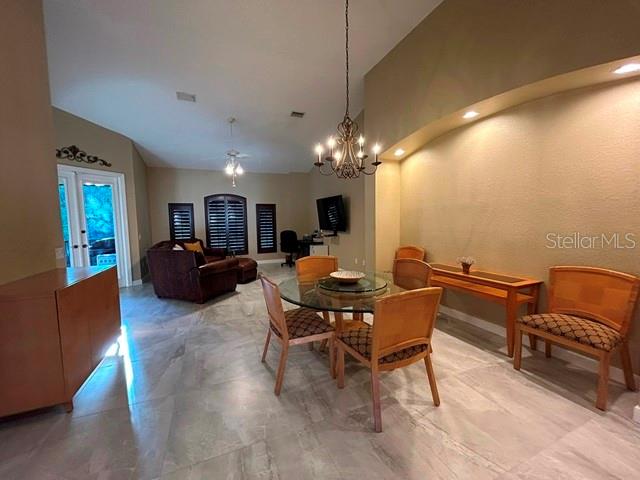 A dining area with a chandelier, tile floors, and a wooden table with chairs — 5461 46TH COURT W, BRADENTON, FL