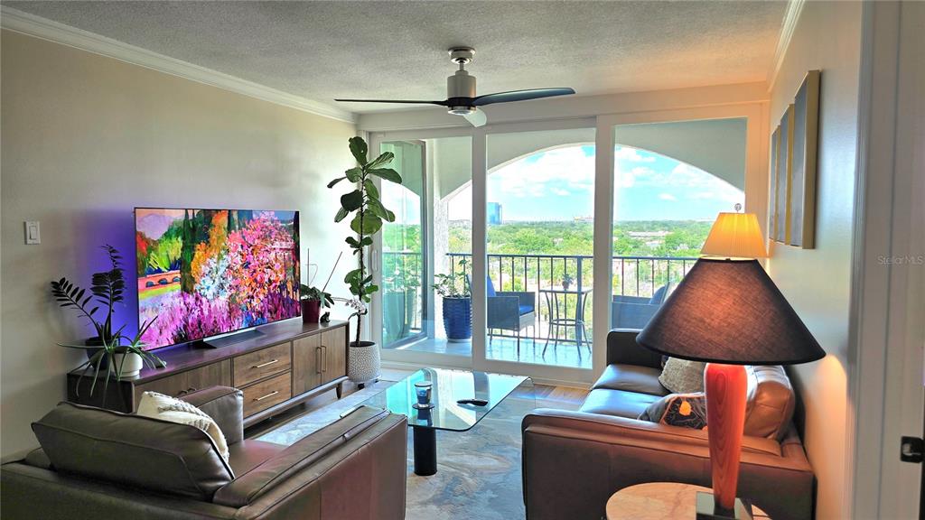 A dining room features a dark wood table, upholstered chairs, blue cabinetry, and recessed lighting — 3211 W SWANN AVENUE UNIT 1110, TAMPA, FL