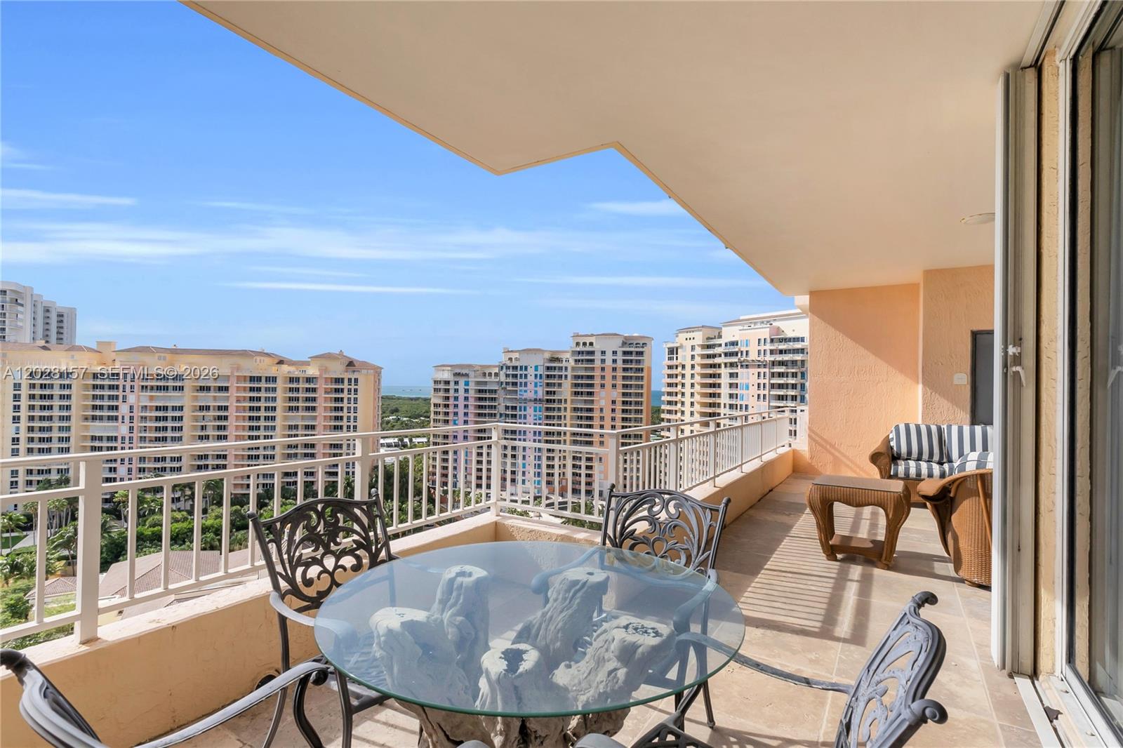A balcony with outdoor furniture overlooks a view of multiple high-rise apartment buildings — 791 Crandon Blvd, Key Biscayne FL 33149, KEY BISCAYNE, FL