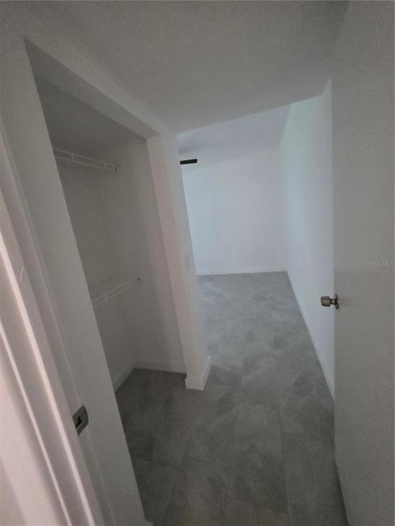 A view through a doorway into a room with gray tile flooring and a closet — 219 HAYS DRIVE, SANFORD, FL