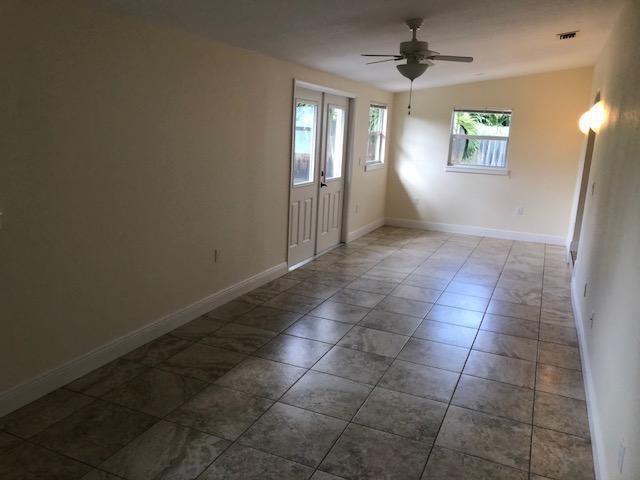 A kitchen features wood cabinets, white appliances, a breakfast bar, and tile flooring — 18966 SE Southgate Drive, Jupiter FL 33469, JUPITER, FL