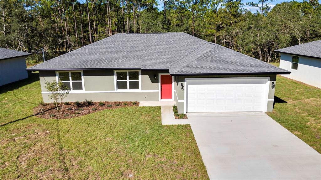 A single-story house with a gray exterior, a red front door, and a two-car garage — 8104 N SANTOS DRIVE, CITRUS SPRINGS, FL