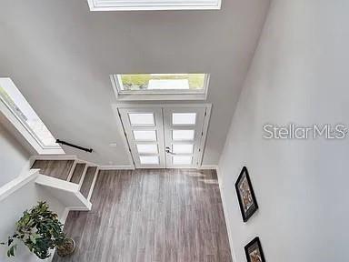 A modern kitchen with white cabinetry and a large island opens to a backyard patio — 200 E GRANT STREET, ORLANDO, FL