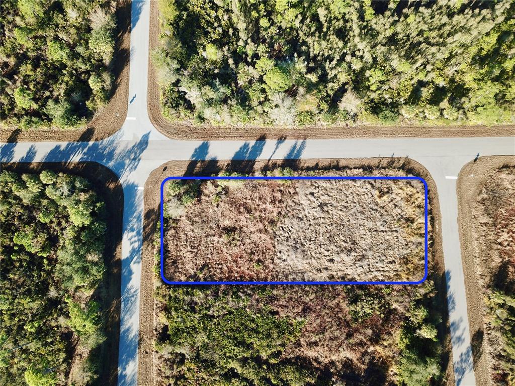An aerial view shows a vacant, rectangular lot outlined in blue at a road intersection — 12373 COLLEGE AVENUE, PORT CHARLOTTE, FL