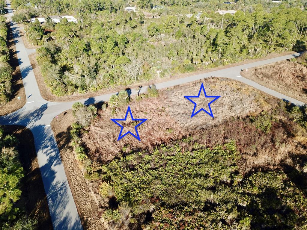 An aerial view shows two vacant, brush-covered lots situated at a paved road intersection — 12373 COLLEGE AVENUE, PORT CHARLOTTE, FL