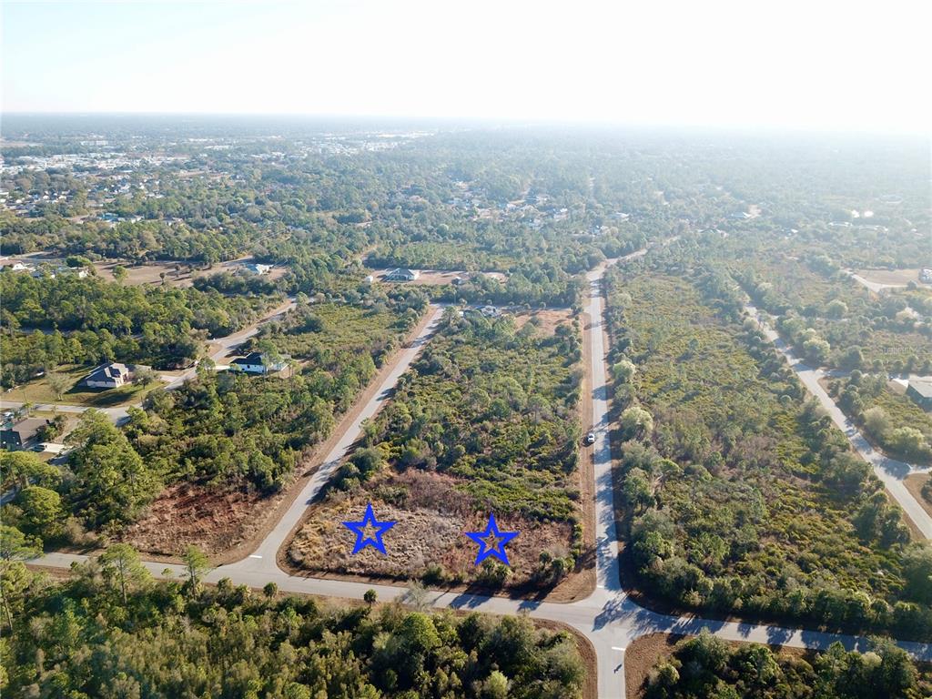 An aerial view shows two adjacent vacant lots marked with blue stars near a road — 12373 COLLEGE AVENUE, PORT CHARLOTTE, FL