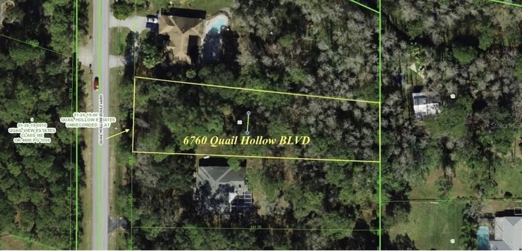 This is an aerial map showing a rectangular parcel of land with surrounding wooded areas — 6760 QUAIL HOLLOW BOULEVARD, WESLEY CHAPEL, FL