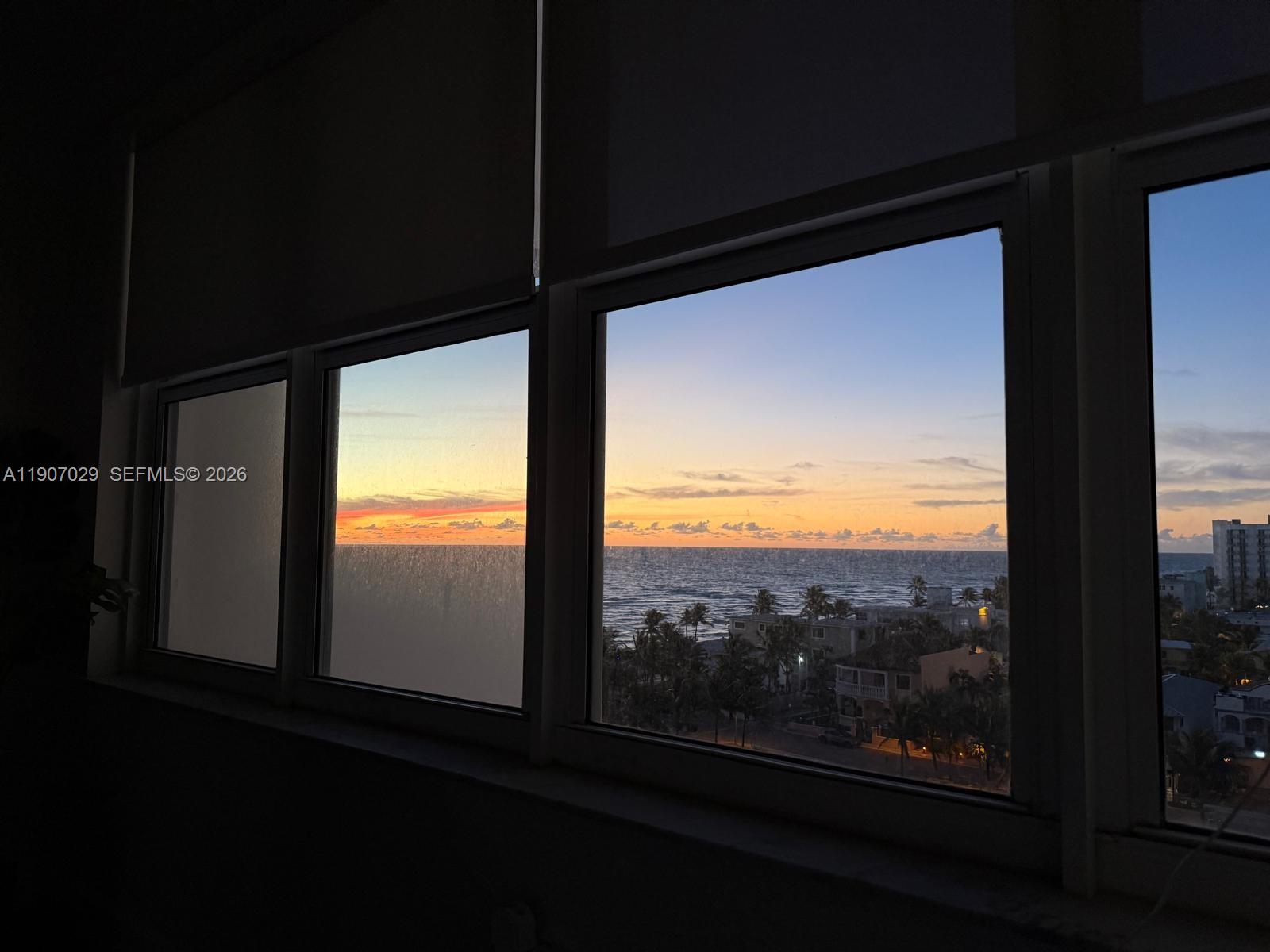 A view of the ocean and sunset through a series of large windows — 3111 N Ocean Dr # 811, Hollywood FL 33019, HOLLYWOOD, FL