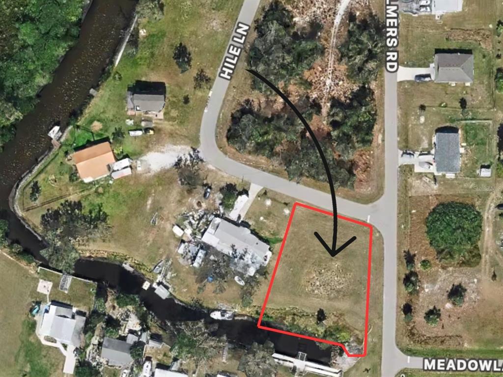 An aerial map view shows a vacant rectangular lot outlined in red near a canal — 405 HILE LANE, PUNTA GORDA, FL