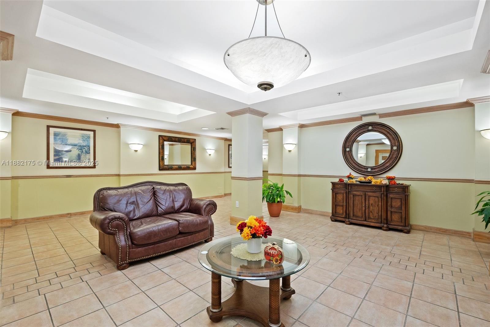 A lobby area features a brown leather sofa, a glass coffee table, and a wooden sideboard — 9805 NW 52nd St # 216, Doral FL 33178, DORAL, FL