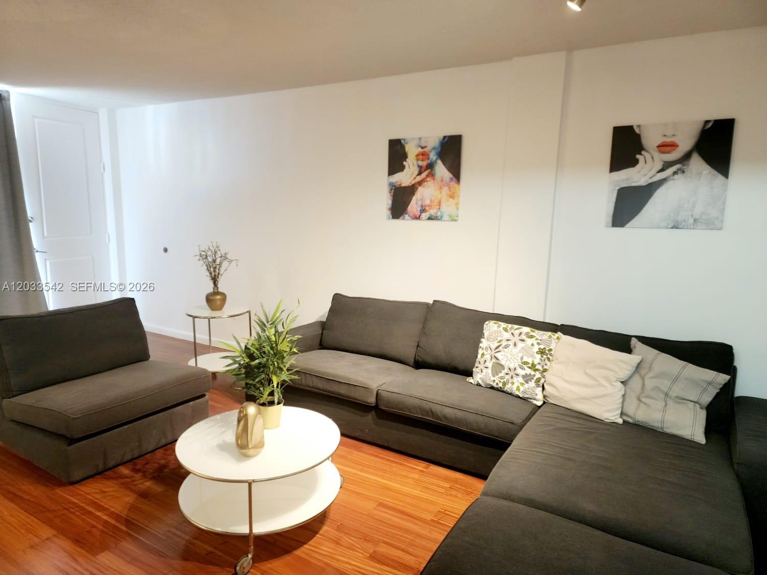 A living room features a dark sectional sofa, a matching armchair, and a white coffee table — 1100 Alton Rd # 3C, Miami Beach FL 33139, MIAMI BEACH, FL