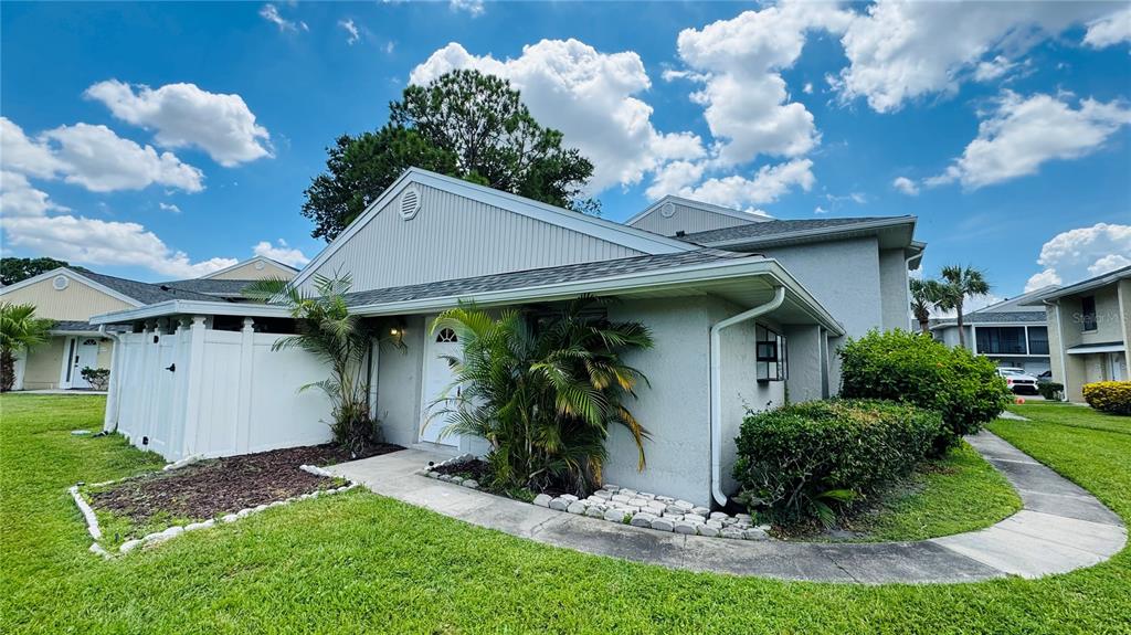 A light-colored residential building features a white front door, palm trees, and a sidewalk — 4415 PINEBARK AVENUE UNIT 48-4, ORLANDO, FL