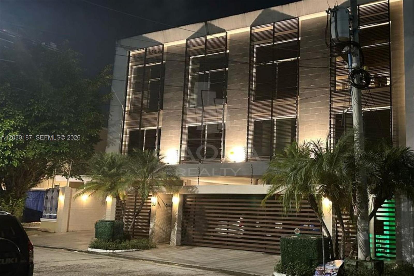 A three-story modern building features horizontal wood slat screens and exterior accent lighting at night — 0 MARBELLA Panama Republic of Panama, FL, FL
