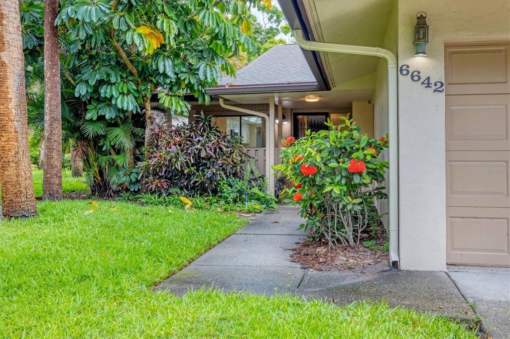 A concrete walkway leads to the front entrance of a house with a garage — 6642 SCHOONER BAY CIRCLE UNIT 6642, SARASOTA, FL