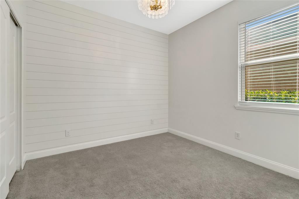 A bedroom with gray carpet, light gray walls, and a white shiplap accent wall — 549 CHAMPION RIDGE DRIVE, DAYTONA BEACH, FL
