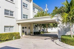 A white multi-story building features a covered driveway entrance and manicured hedges — 1439 S Ocean Boulevard # 217, Pompano Beach FL 33062, POMPANO BEACH, FL