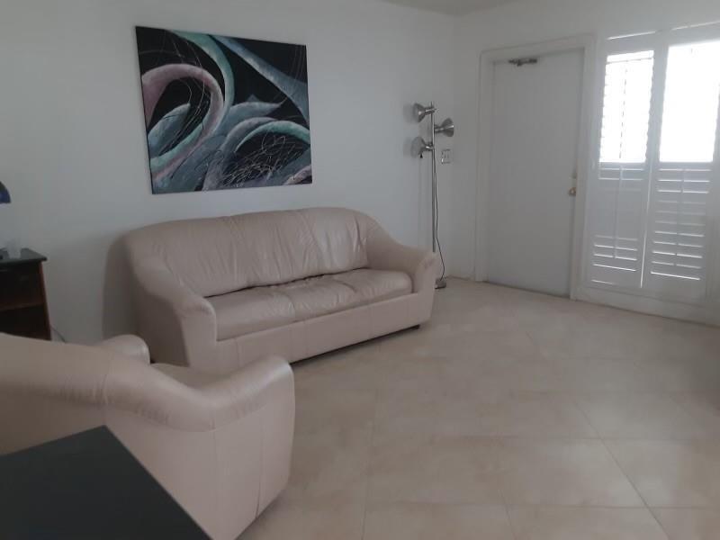 A living room features a beige leather sofa, a matching armchair, and tile flooring — 1439 S Ocean Boulevard # 217, Pompano Beach FL 33062, POMPANO BEACH, FL