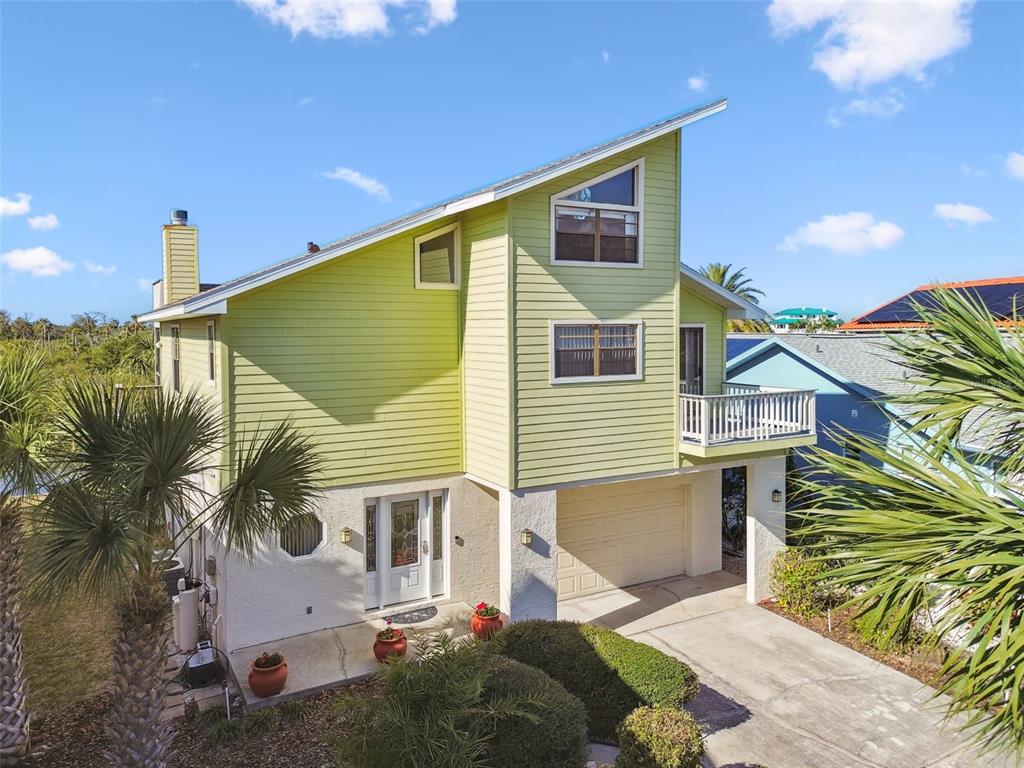 A two-story house with lime green siding, a white stucco base, and a garage — 6321 GARLAND COURT, NEW PORT RICHEY, FL