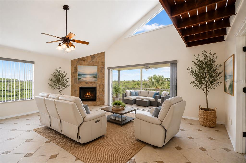 A living room features a stone fireplace, vaulted ceiling, and sliding doors opening to a patio — 6321 GARLAND COURT, NEW PORT RICHEY, FL