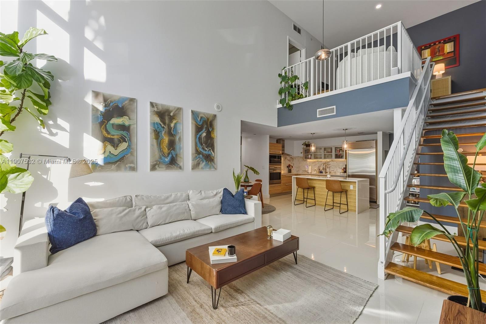 A modern living room with high ceilings, a loft, and an open kitchen with island seating — 2020 N Bayshore, Miami FL 33137, MIAMI, FL