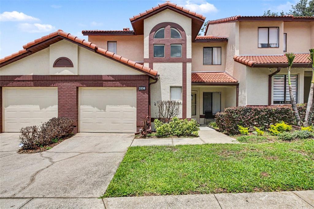 A multi-unit residential building with a tiled roof, stucco exterior, and attached garages — 3336 GRAY FOX COVE UNIT 3336, APOPKA, FL