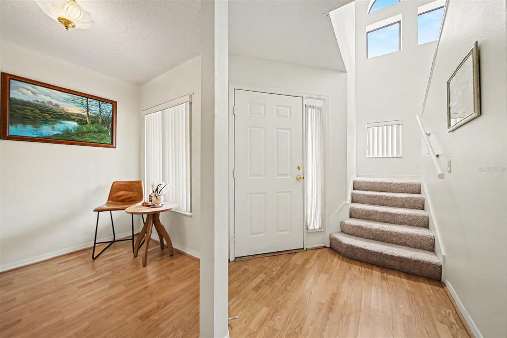 A dining area with a wooden table, six chairs, and a chandelier on light flooring — 3336 GRAY FOX COVE UNIT 3336, APOPKA, FL
