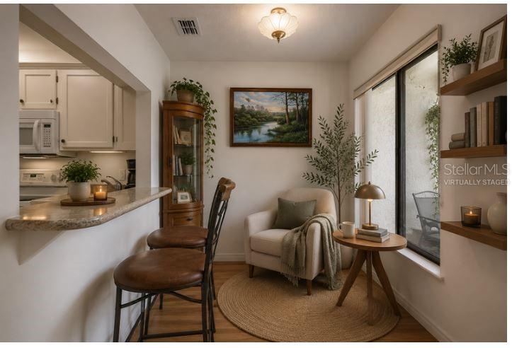 A living room with high ceilings, light wood floors, and an adjacent dining area — 3336 GRAY FOX COVE UNIT 3336, APOPKA, FL