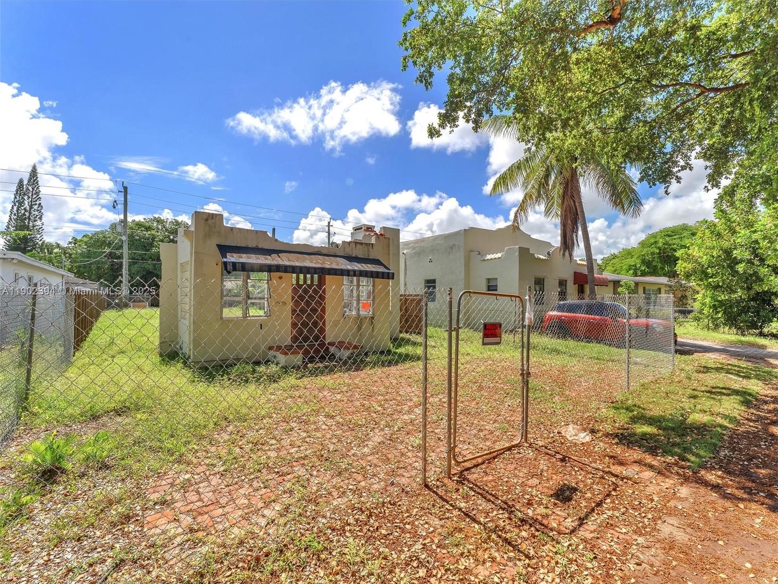 A small, single-story house with a chain-link fence and a brick driveway — 1928 Dewey St, Hollywood FL 33020, HOLLYWOOD, FL