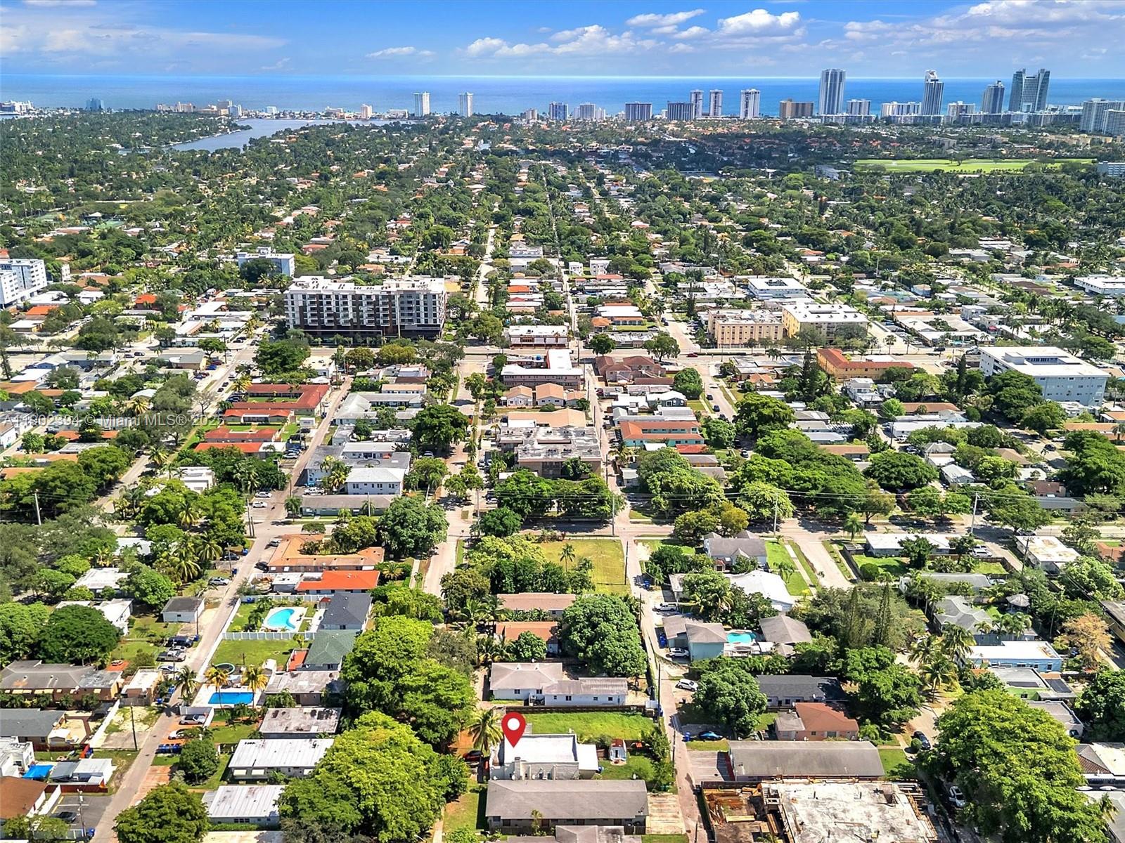 An aerial view shows a residential neighborhood with a red location pin on a house — 1928 Dewey St, Hollywood FL 33020, HOLLYWOOD, FL