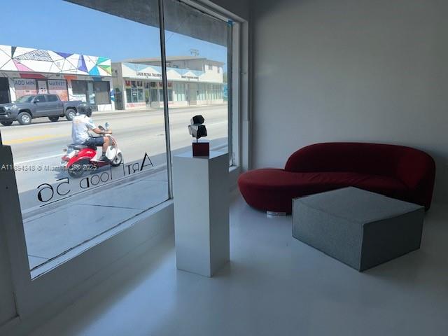 A modern interior space features a red sofa, a gray ottoman, and a pedestal — 5600 NW 7th Ave, Miami FL 33127, MIAMI, FL