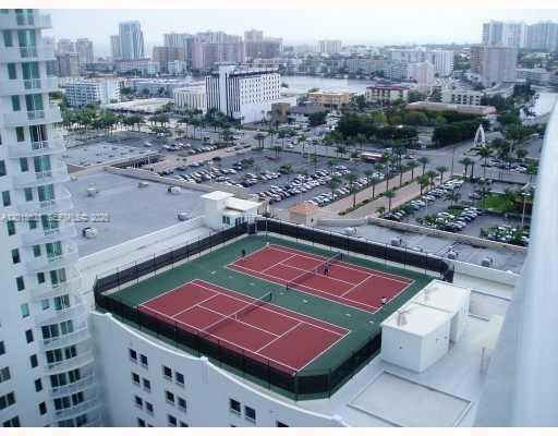 An aerial view shows two tennis courts on a building rooftop overlooking a city skyline — 1745 E Hallandale Beach Blvd # 802W, Hallandale Beach FL 33009, HALLANDALE BEACH, FL