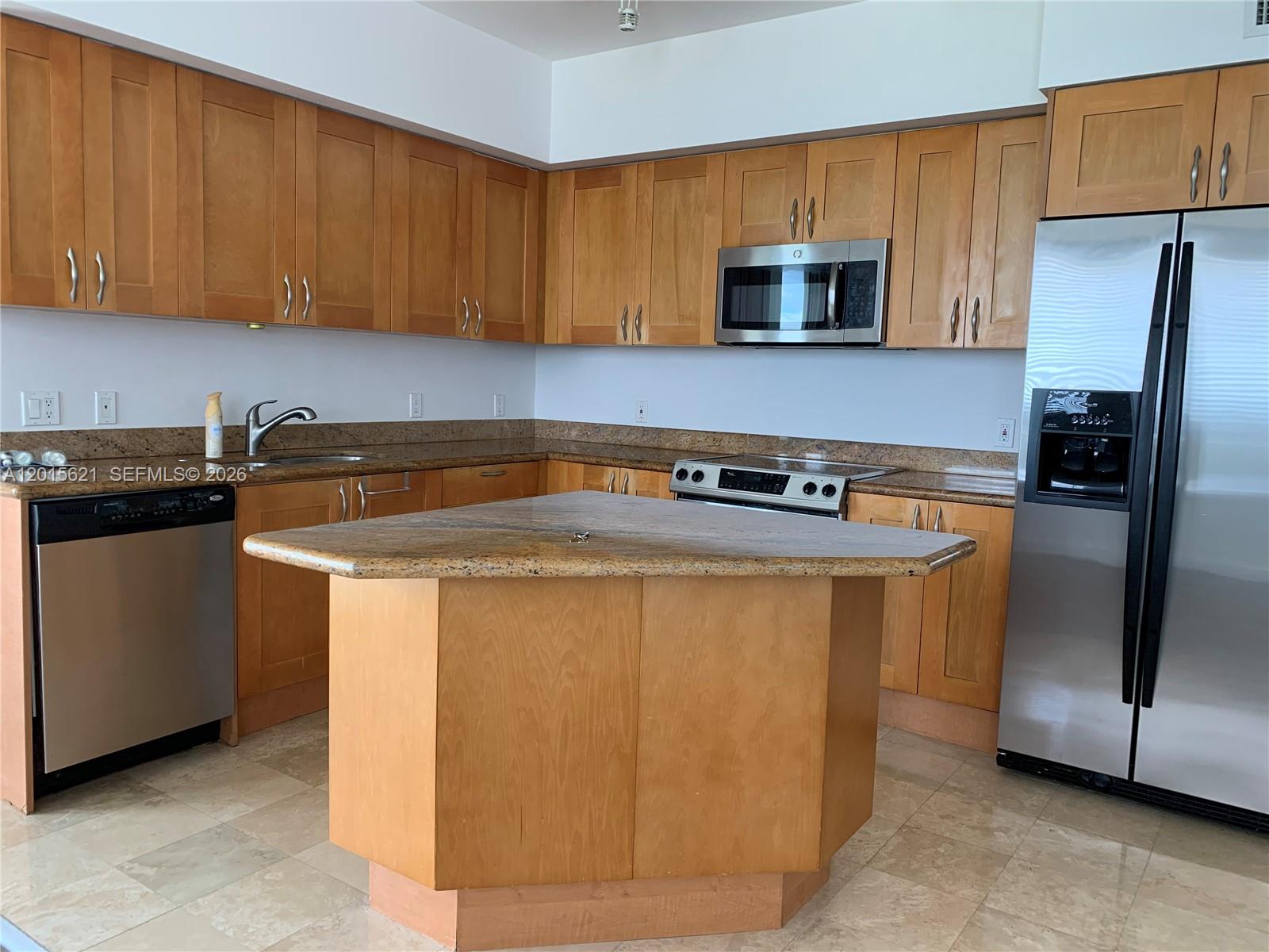 A kitchen features light wood cabinets, granite countertops, stainless steel appliances, and a central island — 1745 E Hallandale Beach Blvd # 802W, Hallandale Beach FL 33009, HALLANDALE BEACH, FL