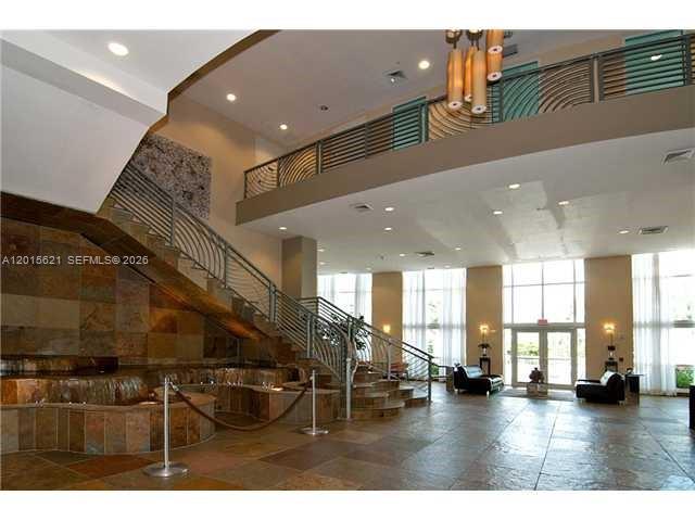 A spacious lobby features a stone staircase, a water feature, and a second-floor balcony railing — 1745 E Hallandale Beach Blvd # 802W, Hallandale Beach FL 33009, HALLANDALE BEACH, FL