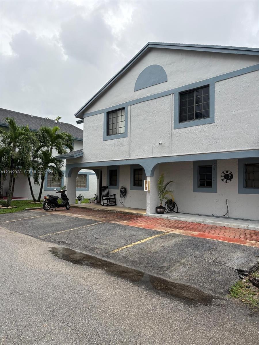 A two-story building with a covered patio, parking spaces, and palm trees in front — 1405 SW 122nd Ave # 13, Miami FL 33184, MIAMI, FL
