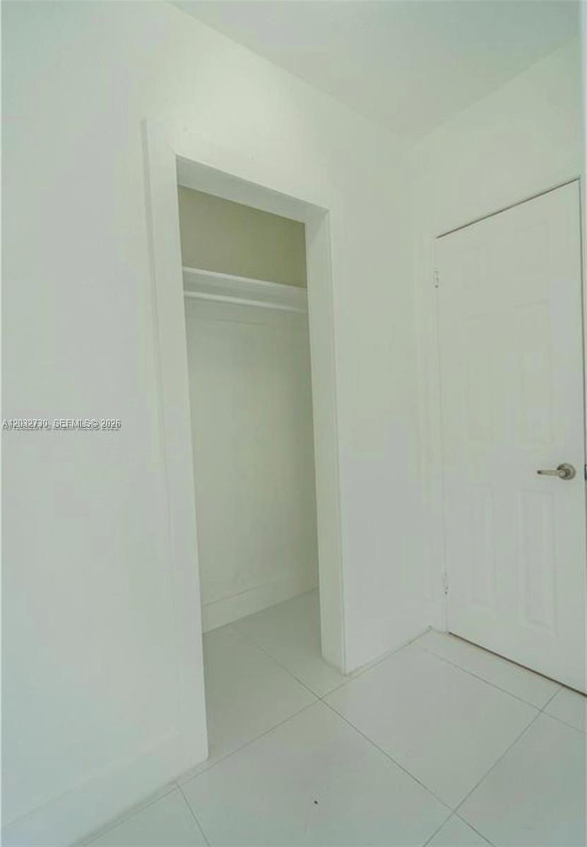 A white room features a closet with a shelf and a closed white door — 7935 Crespi Blvd # 3, Miami Beach FL 33141, MIAMI BEACH, FL