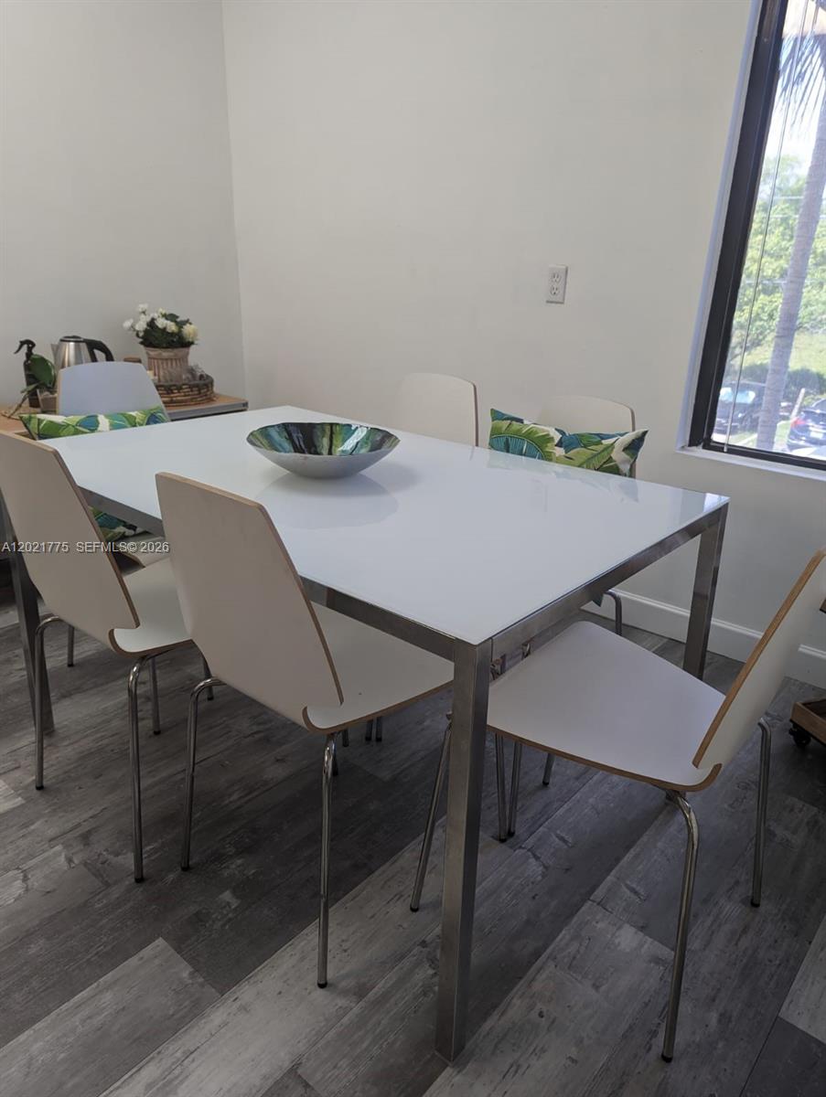 A dining room features a white table with chrome legs and four matching chairs — 12550 Biscayne Blvd # 220, North Miami FL 33181, NORTH MIAMI, FL