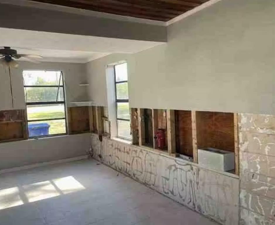 A side yard features a stucco house wall, a white fence, and a fallen tree — 806 W SHELL POINT ROAD, RUSKIN, FL