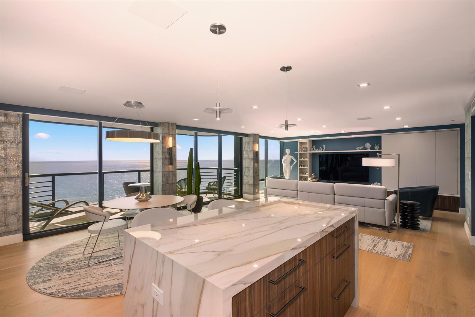 A modern open-concept living and dining area features a marble kitchen island and ocean views — 250 S Ocean Boulevard # F, Boca Raton FL 33432, BOCA RATON, FL