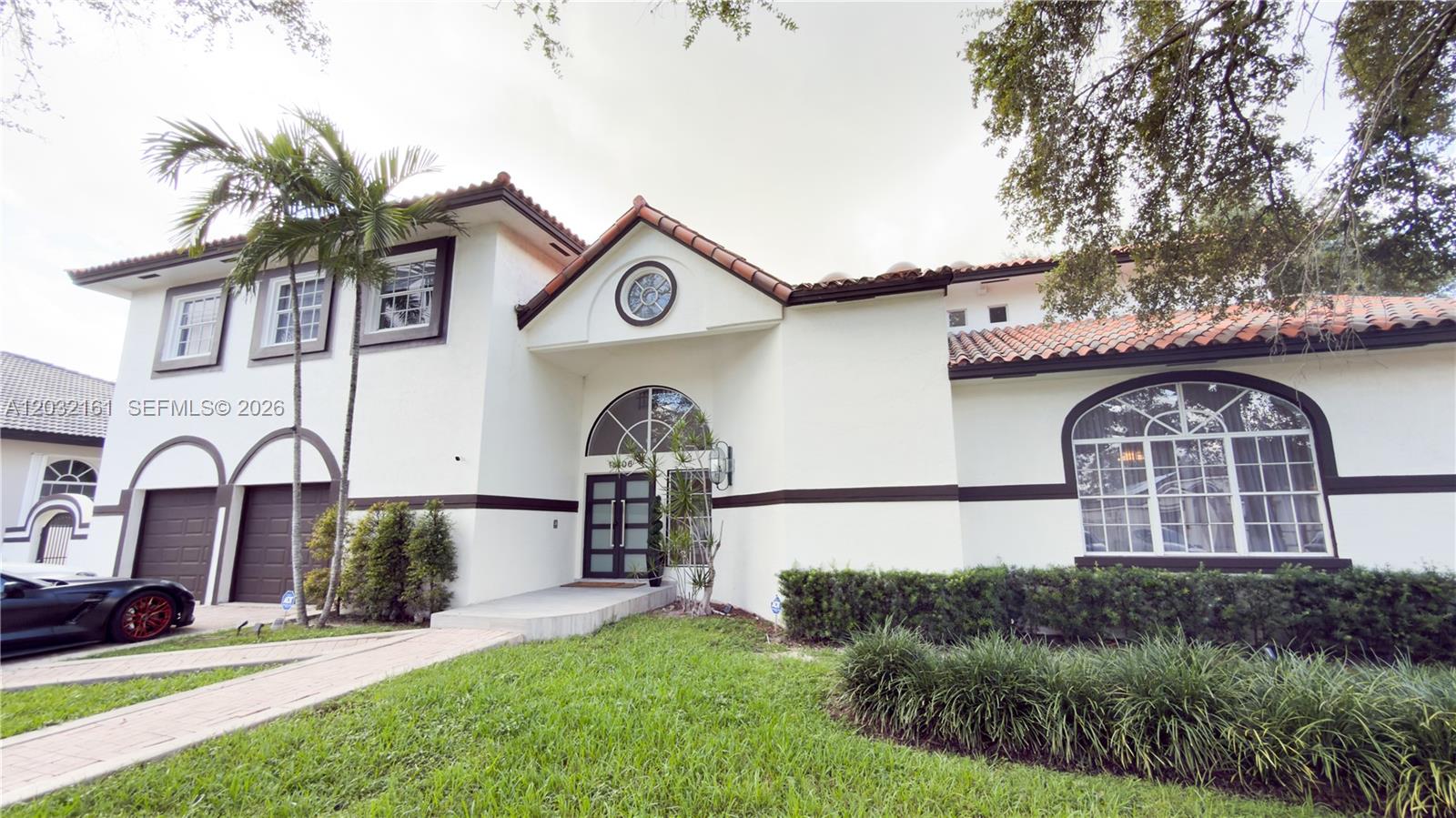 A two-story stucco house with a tile roof, arched windows, and a two-car garage — 15106 NW 89th Ct, Miami Lakes FL 33018, MIAMI LAKES, FL