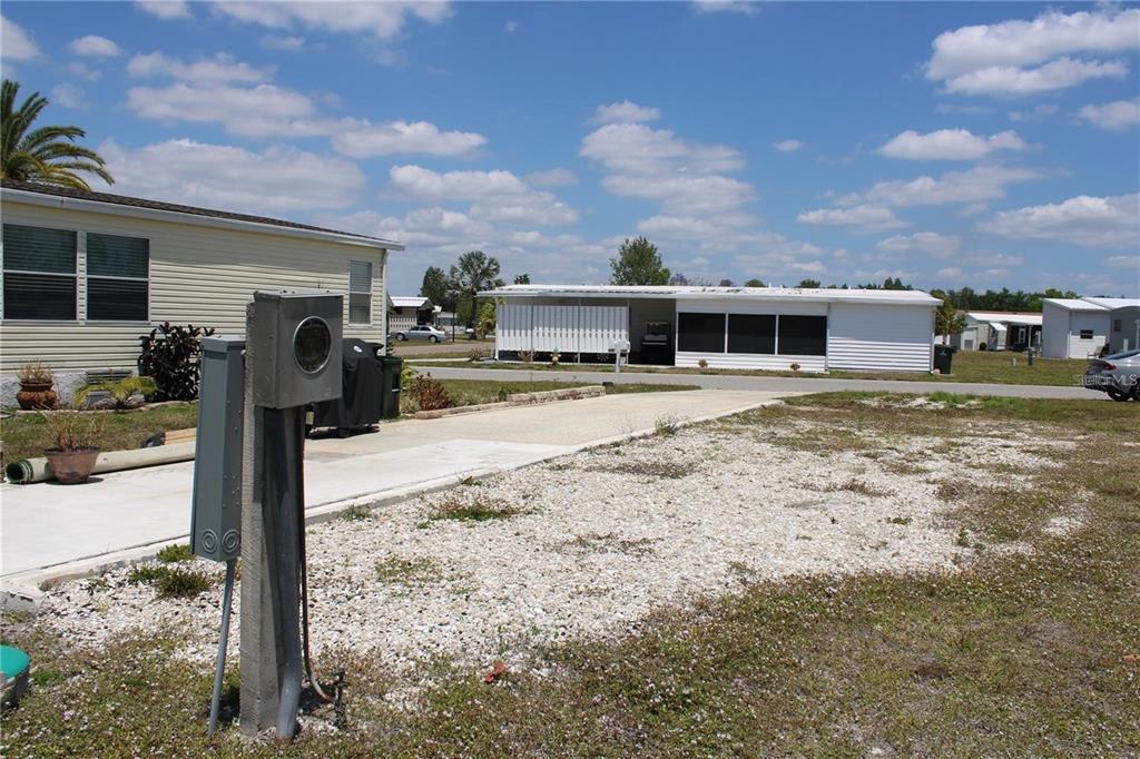 A gravel lot with a concrete driveway sits in front of a mobile home — 5150 PALENA BOULEVARD UNIT 294, NORTH PORT, FL