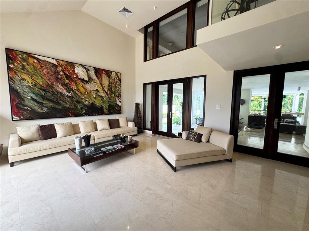 A spacious living room features high ceilings, marble floors, a large abstract painting, and furniture — #9 Palma Real ESTANCIAS DE TORRIMAR, GUAYNABO, PR
