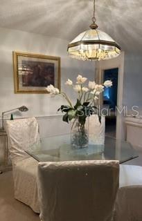 A dining area features a glass table, slipcovered chairs, and a decorative pendant light fixture — 8519 SW 91ST STREET UNIT B, OCALA, FL