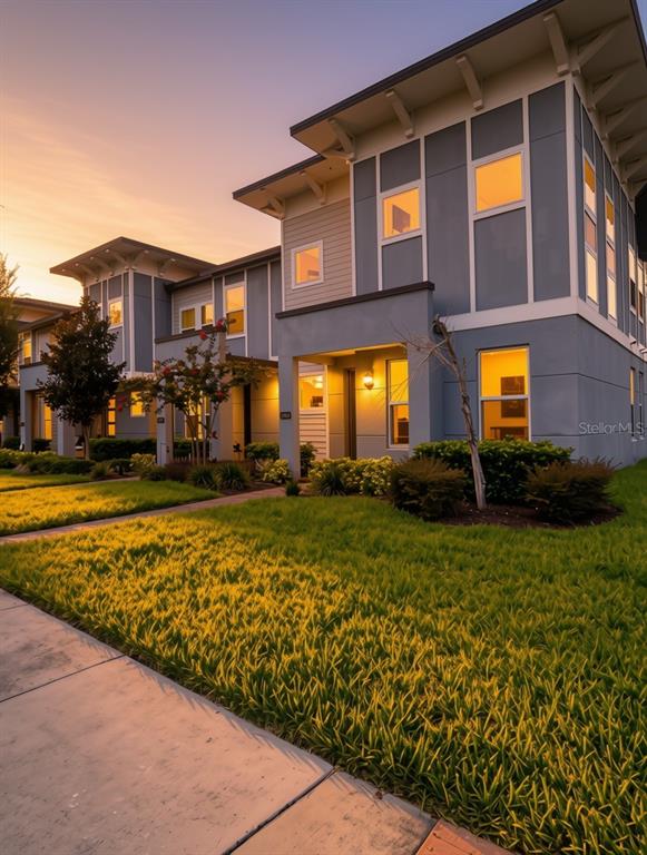 A two-story modern house with a blue facade, flat roof, and brick walkway — 5898 BIMINI TWIST LOOP, ORLANDO, FL