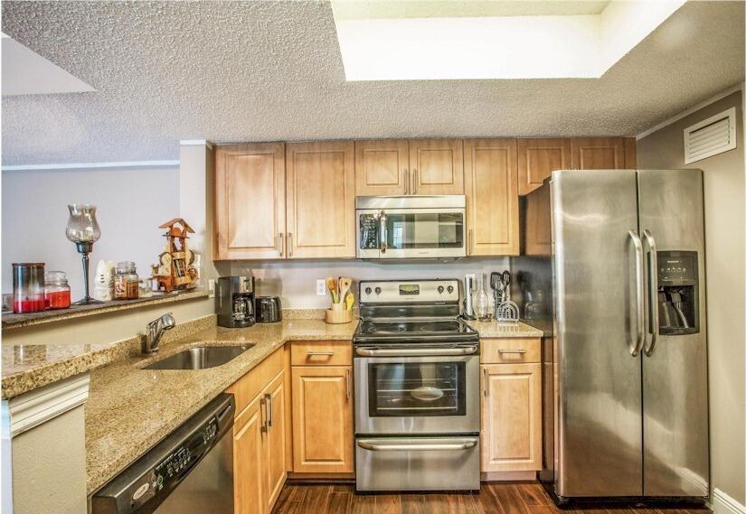 A kitchen with light wood cabinets, stainless steel appliances, and granite countertops — 8935 Okeechobee Boulevard # 204, West Palm Beach FL 33411, WEST PALM BEACH, FL