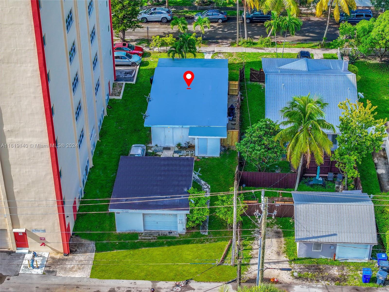 An aerial view shows a house with a blue roof next to a large apartment building — 1711 Buchanan St, Hollywood FL 33020, HOLLYWOOD, FL