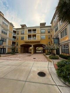 A multi-story apartment building features a central arched breezeway and a paved driveway — 860 N ORANGE AVENUE UNIT 146, ORLANDO, FL