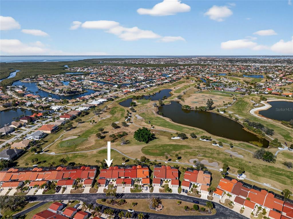 An aerial view shows a row of townhomes overlooking a golf course and lake — 5061 SAN ROCCO COURT, PUNTA GORDA, FL